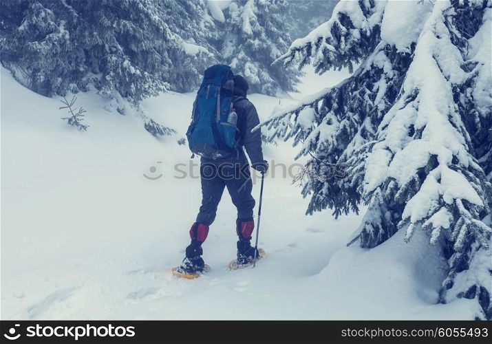 Hiker with snowshoes in winter