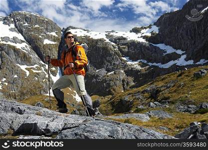 Hiker with walking sticks in mountains