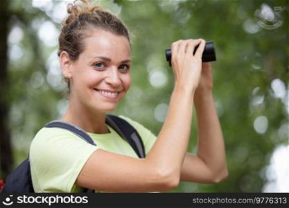 hiker woman looking in binoculars in nature