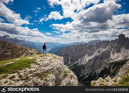 Hiker woman standing up achieving the top. National Nature Park Tre Cime In the Dolomites Alps. Beautiful nature of Italy.