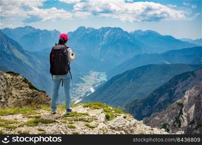 Hiker woman standing up achieving the top. National Nature Park Tre Cime In the Dolomites Alps. Beautiful nature of Italy.