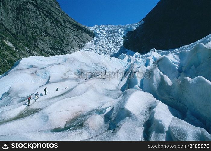 Hikers climbing a mountain, Briksdalsbreen Glacier, Norway