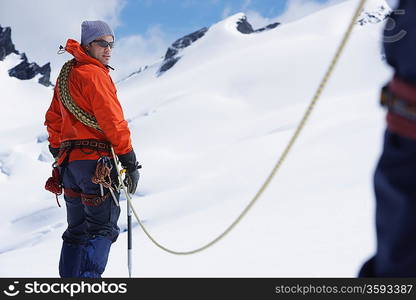 Hikers joined by safety line in snowy mountains