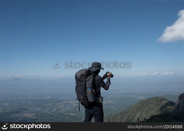 hikers traveling with backpacks taking pictures on the top of the mountain