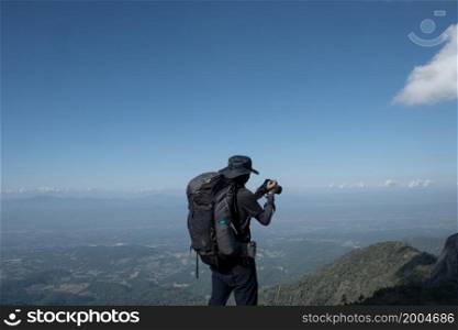 hikers traveling with backpacks taking pictures on the top of the mountain