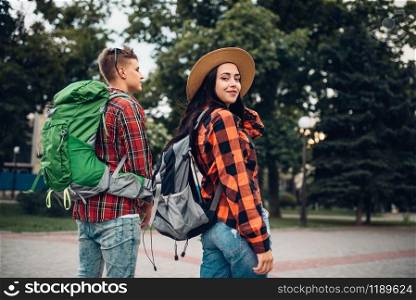 Hikers with backpacks traveling in tourist town. Summer hiking. Hike adventure of young man and woman. Hikers with backpacks traveling in tourist town