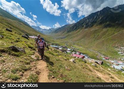 Hikers with large backpacks hiking on mountain Kackarlar,a mountain range that rises above Black Sea coast in eastern Rize,Turkey.16 August 2016. hikers with large backpacks hiking on mountain Kackarlar