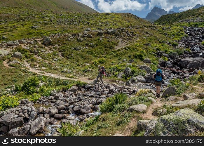 Hikers with large backpacks hiking on mountain Kackarlar,a mountain range that rises above Black Sea coast in eastern Rize,Turkey.16 August 2016. hikers with large backpacks hiking on mountain Kackarlar