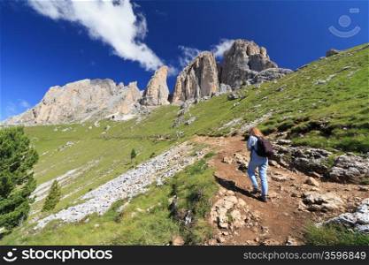 hiking beneath Sassolungo Mount on summer, Trentino, Italy