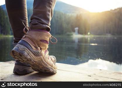 hiking boots close-up against the mountain lake synevyr. Carpathians, Ukraine.