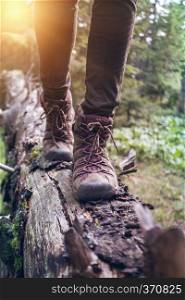 hiking boots close-up. girl tourist steps on a log