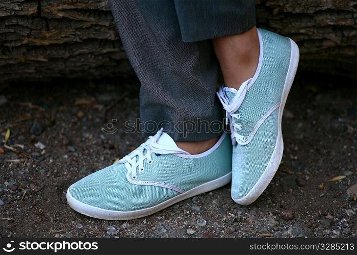 hiking - closeup of womens feet in light blue sneakers in the wood
