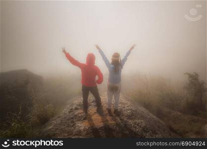 Hiking couple happy to reach the top of a mountain