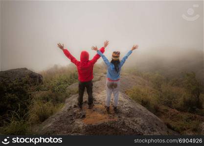 Hiking couple happy to reach the top of a mountain
