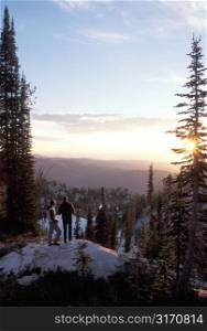 Hiking Couple Standing At A Mountain Overlook And Watching The Sun Rise