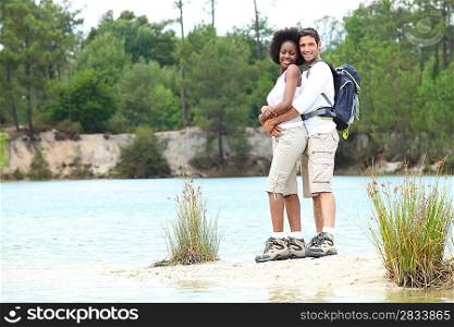 Hiking couple stood by lake