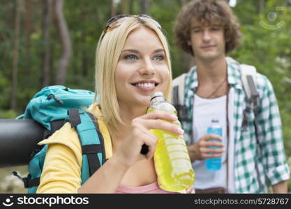 Hiking couple with energy drinks in forest