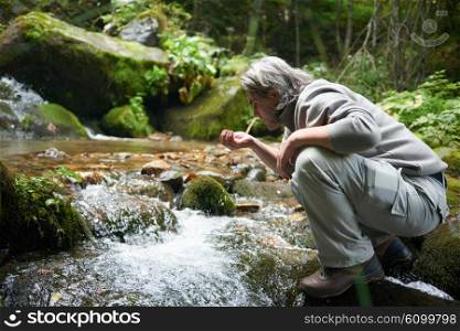 hiking in beautiful nature, man drink fresh water from spring