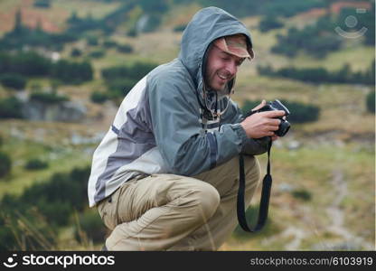 hiking man prepare tasty sausages on campfire in mountains