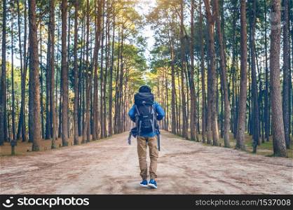 hiking man with backpack walking in forest.