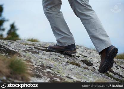 hiking man with trekking boots on the trail in height mountains
