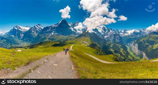Hiking trail to summit of mountain Mannlichen with popular viewpoint in Swiss Alps, Switzerland. Eiger, Monch and Jungfrau mountains, Grindelwald and Lauterbrunnen valleys in the background.. Mountain Mannlichen, Switzerland