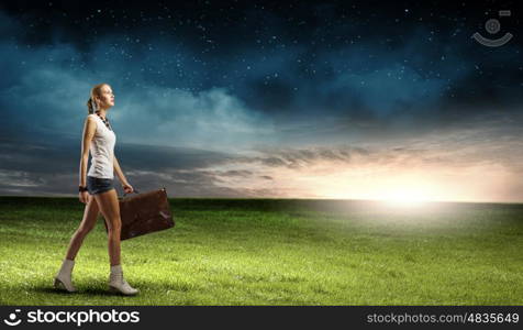 Hiking traveling. Young woman hiker walking with suitcase in hand