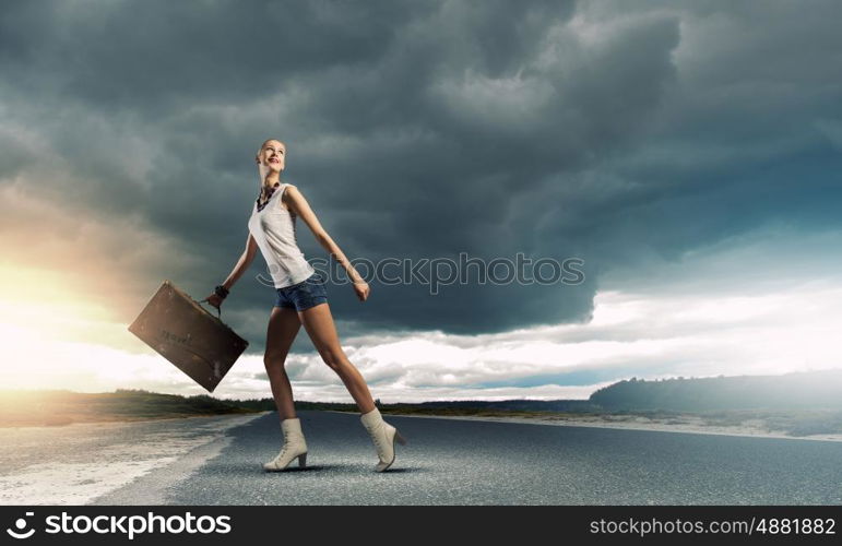 Hiking traveling. Young woman hiker walking with suitcase in hand