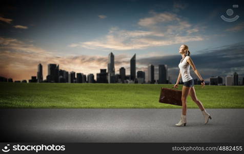 Hiking traveling. Young woman hiker walking with suitcase in hand