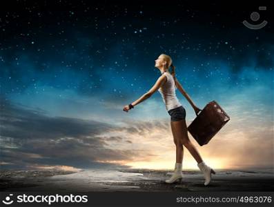 Hiking traveling. Young woman hiker walking with suitcase in hand