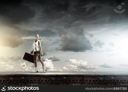 Hiking traveling. Young woman hiker walking with suitcase in hand