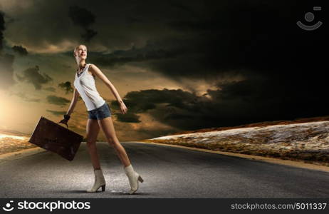 Hiking traveling. Young woman hiker walking with suitcase in hand