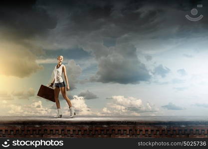 Hiking traveling. Young woman hiker walking with suitcase in hand