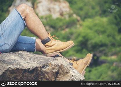 Hiking walk on mountain with trekking brown boots explorer on rock mountain view. Adventure man journey Freedom Lifestyle concept.