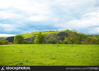 hill on a background of green field