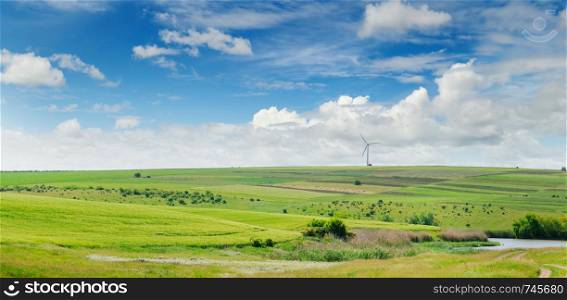 Hilly field and blue sky. Agricultural landscape. Wide photo. Summer background.