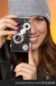 Hip Attractive Woman in Beanie Cap Snaps a Picture with Vintage Camera