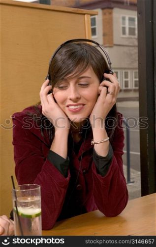 Hip Caucasian Girl Listening To Headphones In A Cafe