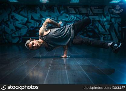 Hip hop action, male dancer motions in dance studio. Modern urban dancing style