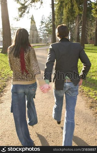 Hip Urban Couple Walking Together Through A City Park