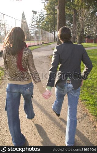 Hip Urban Couple Walking Together Through A City Park