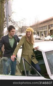 Hip Young Man Opening The Car Door For His Stylish Girlfriend