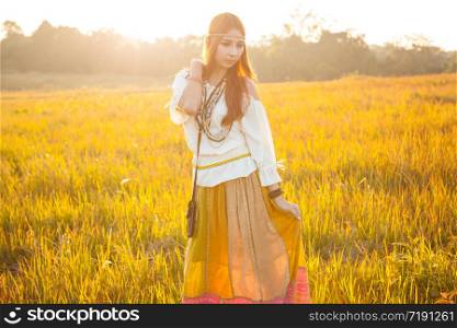 Hippie woman posing in golden field on sunset