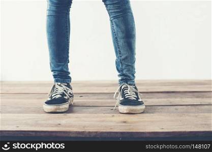 hipster cool woman feet with black sneakers, soft vintage toned . hipster cool woman feet with black sneakers, soft vintage toned colors.