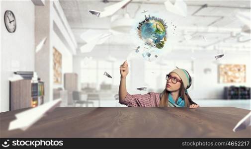 Hipster girl looking from under table. Attractive student girl in red glasses peeping from under table. Elements of this image are furnished by NASA