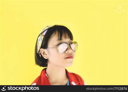 Hipster girl portrait of pleasant lovely short hair with glasses / Happy young asian teen girl fashion woman beauty funny on yellow background