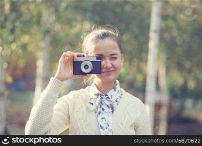 Hipster girl shooting on film camera outdoor