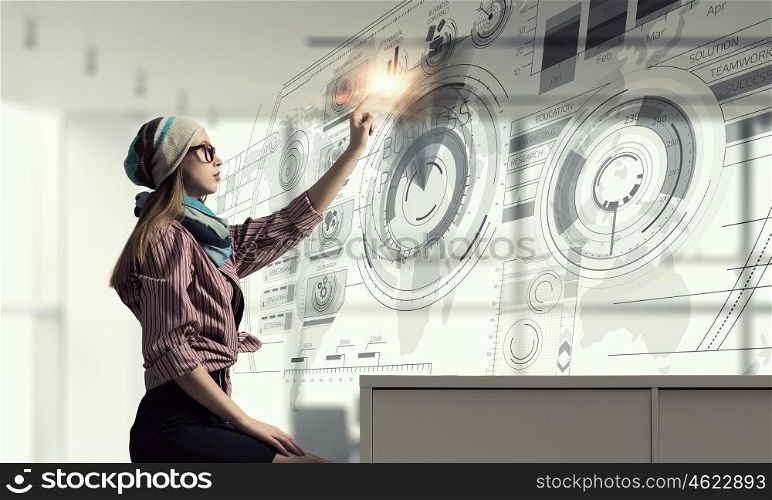 Hipster girl touch media screen. Young girl sitting at table and using virtual interface