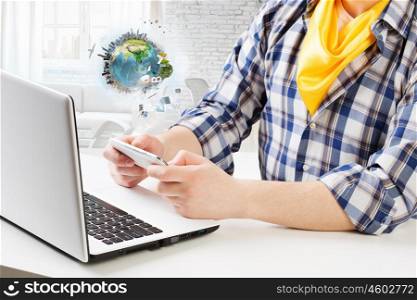 Hipster guy use laptop. Close view of guy in checked shirt using mobile phone and laptop. Elements of this image are furnished by NASA