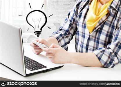 Hipster guy use laptop. Close view of guy in checked shirt using mobile phone and laptop